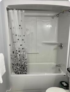 a white bathroom with a shower and a toilet at Cozynest in Moncton
