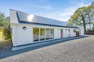 a white building with a solar roof on it at 3 Bed in Bush oc-m31847 in Bude