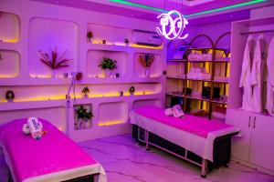 a room with two beds and pink lighting at Soulmate Hotels and Suites in Mawere +32 photos