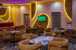 a waiting room with chairs and tables and a tv at Soulmate Hotels and Suites in Mawere