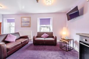 a living room with two couches and a tv at 2 Bed in Tenby oc-w28985 in Tenby
