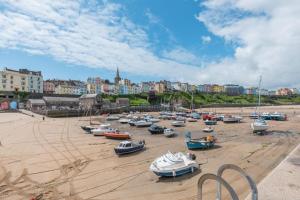 a group of boats sitting on the sand on a beach at 2 Bed in Tenby oc-w28985 in Tenby
