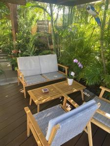 a patio with a bench and a table and chairs at P'ti coin zen in Saint-Gilles-les-Bains