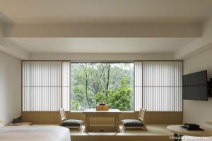 a room with a bed and a large window at Banyan Tree Higashiyama Kyoto in Kyoto