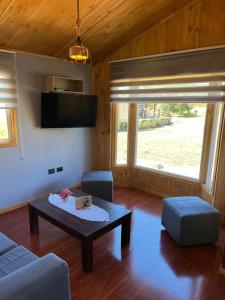 a living room with a coffee table and a couch at cabaña alerce lago panguipulli in Panguipulli
