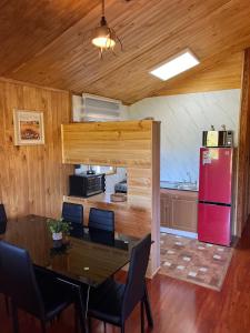 a dining room with a table and a red refrigerator at cabaña alerce lago panguipulli in Panguipulli