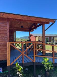 a wooden pergola with a wooden gate on a deck at cabaña alerce lago panguipulli in Panguipulli