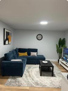 a living room with a blue couch and a table at Cozynest in Moncton