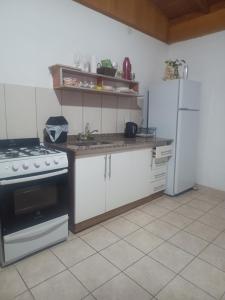 a kitchen with a stove and a white refrigerator at El Portal in Posadas