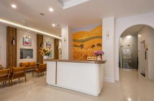 a lobby with a counter and a painting on the wall at Palago Binh Thanh Hotel in Ho Chi Minh City