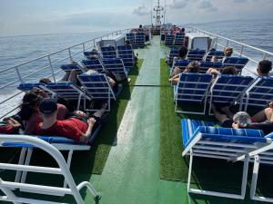 a group of people sitting on the deck of a ferry at Gilibooking tickets in Padangbai