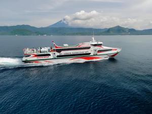 a red and white boat in the water at Gilibooking tickets in Padangbai