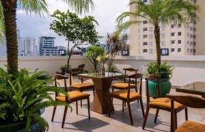 a patio with a table and chairs and palm trees at Palago Binh Thanh Hotel in Ho Chi Minh City