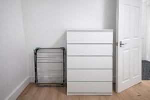 a white cabinet next to a white door at 4-Bed House in Enfield- Sleeps 8- Private garden in Enfield
