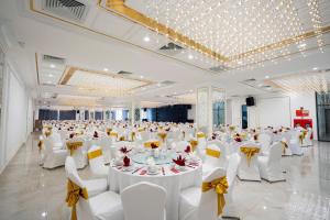 a large banquet hall with white tables and white chairs at Prime Hotel in Thái Nguyên +47 photos