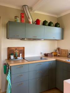 a kitchen with blue cabinets and a counter top at Charming Farmhouse With Views On Møn in Borre