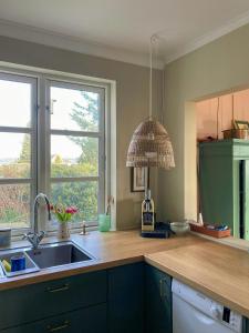 a kitchen with a sink and two windows at Charming Farmhouse With Views On Møn in Borre