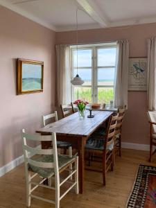 a dining room with a wooden table and chairs at Charming Farmhouse With Views On Møn in Borre +32 photos