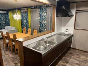a kitchen with a sink and a dining room at 安全な個室貸切に広々した共用スペースの喜久屋コテージクレア in Yamanakako +21 photos