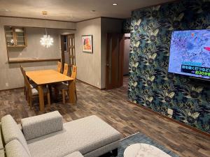 a living room with a table and a tv at 安全な個室貸切に広々した共用スペースの喜久屋コテージクレア in Yamanakako