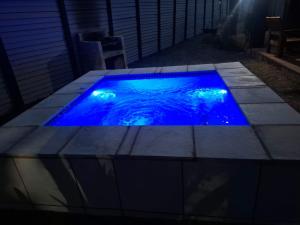 a swimming pool with blue lighting in a backyard at Adam's Inn place in Hartbeespoort
