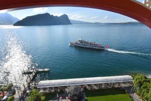 a boat on the water under a bridge at Hotel Vitznauerhof - Lifestyle Hideaway at Lake Lucerne in Vitznau