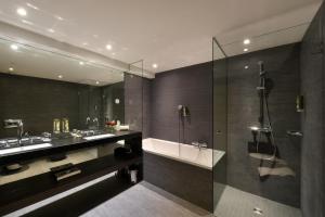 a bathroom with two sinks and a shower at Hotel Vitznauerhof - Lifestyle Hideaway at Lake Lucerne in Vitznau