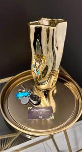 a gold vase on a plate on a glass table at Interno Casa in Sopron