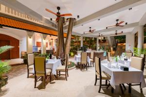 a restaurant with white tables and chairs on a patio at The Sears Residence Siem Reap in Phumĭ Réach Born (2)