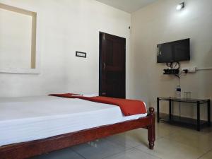a bedroom with a bed and a flat screen tv at Cherai Ocean View Home in Cherai Beach