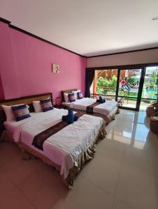 three beds in a room with pink walls at Grand Thai House Resort Lamai in Lamai