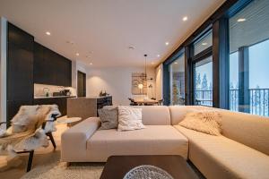 a living room with a couch and a kitchen at Fjällen Aurora Luxe Chalet Ski-in Ski-out by Aavalevi in Levi +44 photos