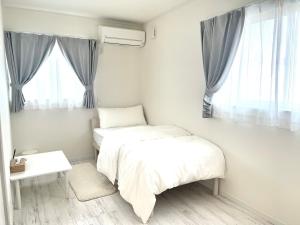 a bedroom with two beds and a window at Sunny Inn Sumida in Tokyo