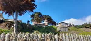 a house on top of a hill with a fence at Cabañita en la Isla in Isla Negra