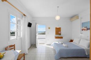 una habitación blanca con dos camas y una mesa en Seample studios, en Chrissi Akti