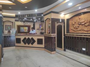 a man standing at a bar in a restaurant at Hotel Rising Sun in Bacha
