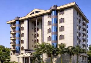 a building with palm trees in front of it at Hotel Rising Sun in Bacha