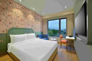 a hotel room with a bed and a tv at Ginger Ekta Nagar, Statue of Unity in Navgam