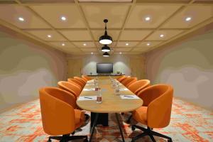 a conference room with a long table and orange chairs at Ginger Ekta Nagar, Statue of Unity in Navgam