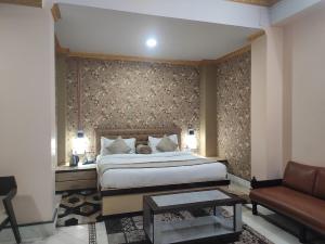 a bedroom with a bed and a couch at Hotel Rising Sun in Bacha