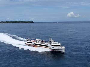 a boat traveling on the water in the ocean at GiliTicket fast ferries in Padangbai