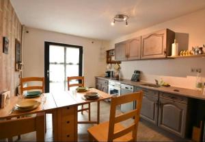 a kitchen with a table and chairs and a kitchen with a counter at Fewo Eifel Dahlem Nationalpark Sonnenterrasse & Kamin in Dahlem