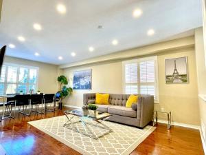 ein Wohnzimmer mit Sofa und Tisch in der Unterkunft Maison Laurier, Modern 5B4B Home Inc BSMT Free parking, Close to trails in Richmond Hill