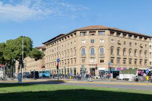 un gran edificio en una calle con gente caminando delante de él en 7Florence, en Florencia