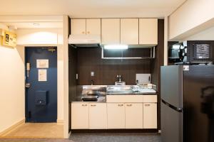 a kitchen with white cabinets and a black refrigerator at StaySpring HARUYOSHI in Fukuoka +25 photos