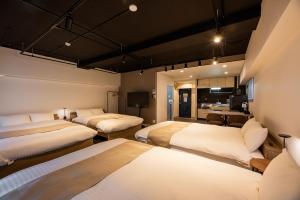 a room with three beds and a kitchen at StaySpring HARUYOSHI in Fukuoka