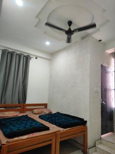 a room with two beds and a ceiling fan at Himalayan siddh yog ashram in Rishīkesh