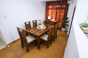 a dining room with a wooden table and chairs at Kandy Royal Resort in Kandy +22 photos