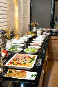 a buffet line with many plates of food at Afrosiyob Regency Hotel in Tashkent +20 photos