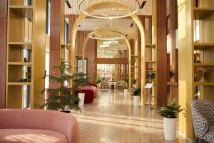 a lobby with a lot of plants in a building at Afrosiyob Regency Hotel in Tashkent